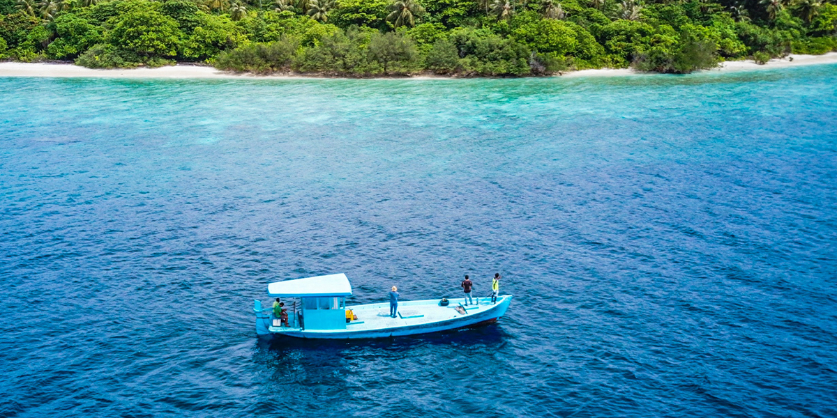 Boat on ocean with tropical island