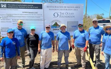 Partners at JBNERR, the Puerto Rico Department of Natural & Environmental Resources, and Merello Marine Consulting standing in front of the new permitted sign in Jobos Bay, Puerto Rico