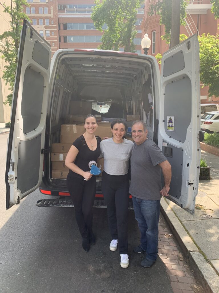 Staff putting equipment in a van to ship