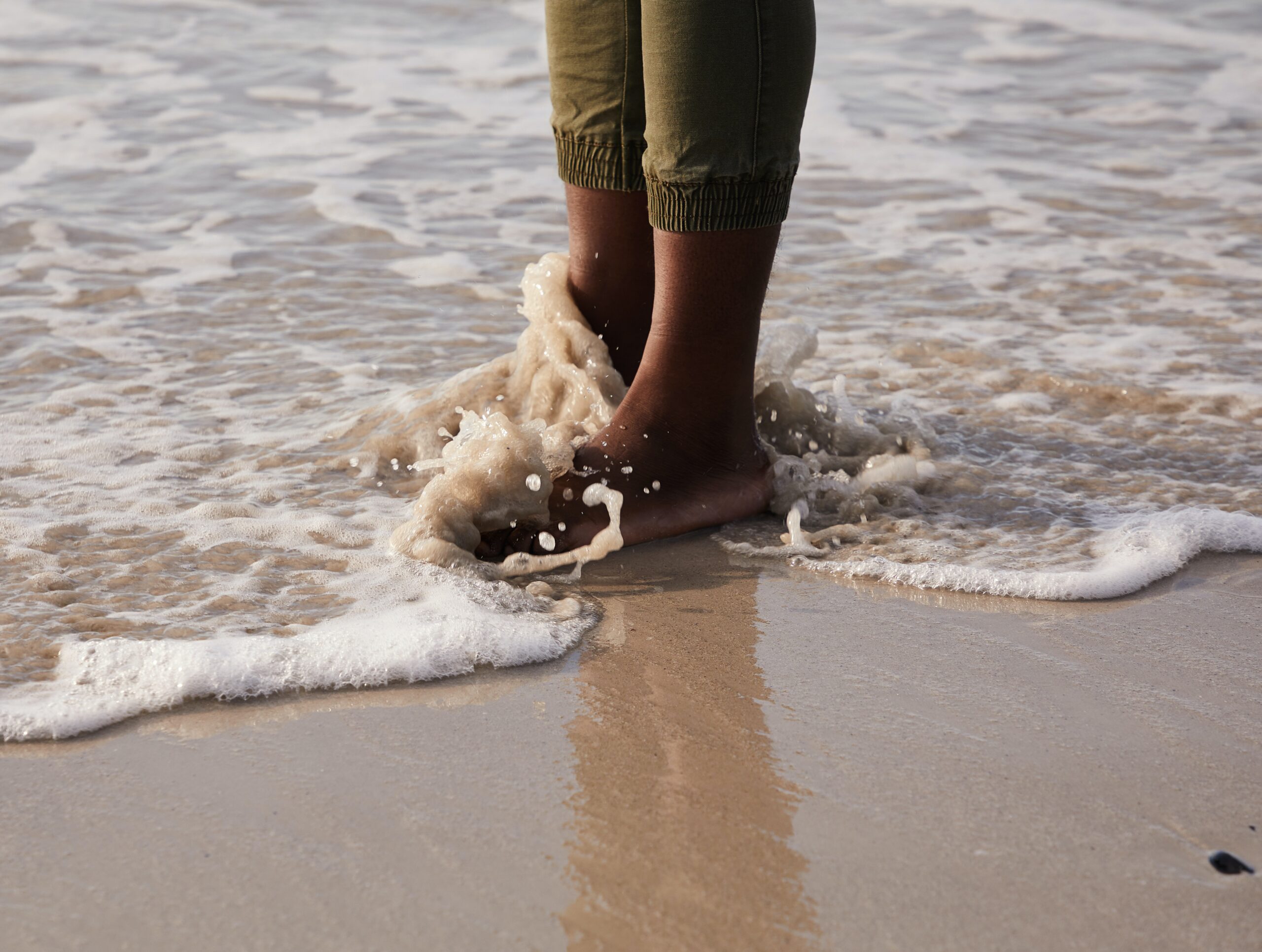 Feet in the sand at the ocean